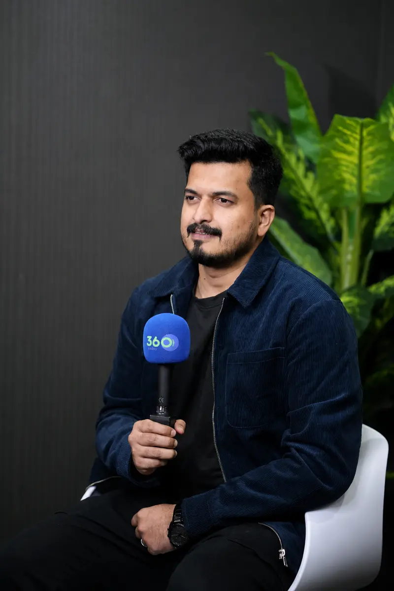 RJ Thanveer seated with a 360 Radio microphone